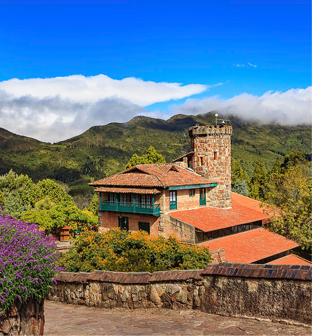 Mountain scape with a house next to a street with the rolling hills in the background