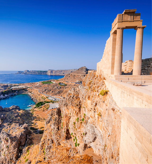 acropolos at the top of a cliff overlooking a bay