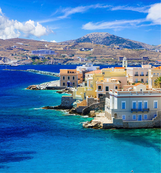 Aerial view of a coastal city next to vibrant blue water 