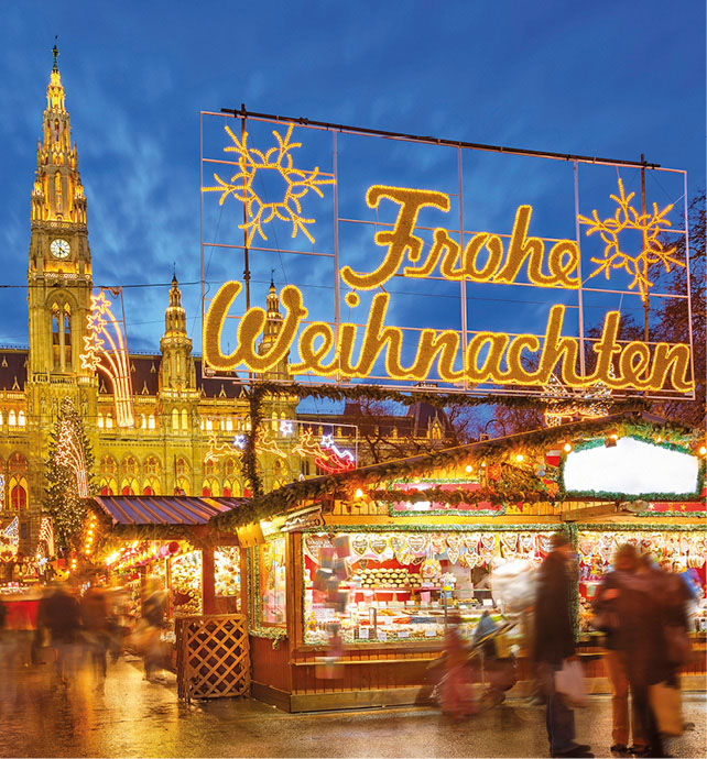 Vienna’s Christmas market situated in front of the City Hall, a lit-up sign reads ‘Frohe Weihnachten’