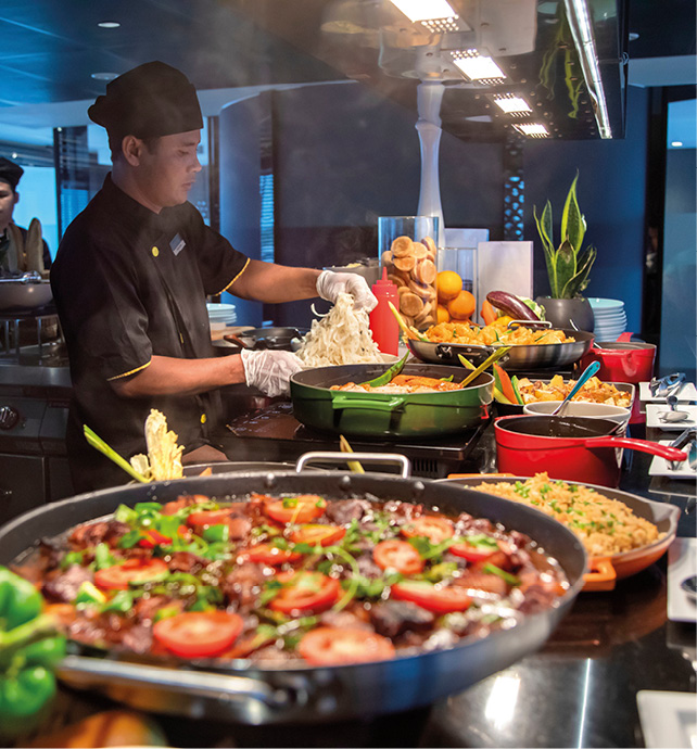 Two expert chefs preparing Southeast Asian cuisine for a buffet with fresh local produce and ingredients