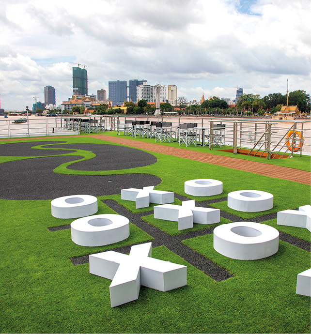 A giant noughts and crosses board, with walking track, with Southeast Asian city in the background