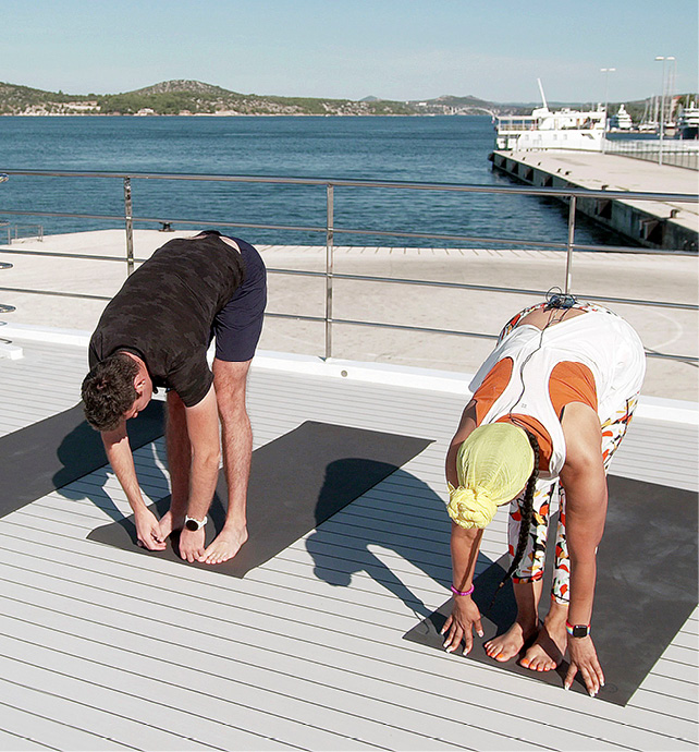 Two guests taking part in a yoga session on a luxury yacht cruise 